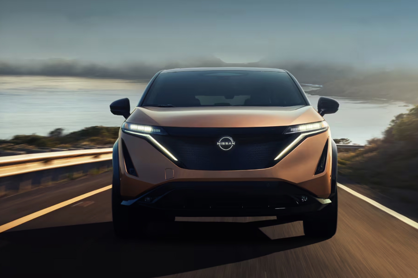 Vue avant d ela nissan Ariya 2025 sur route avec vue sur mer