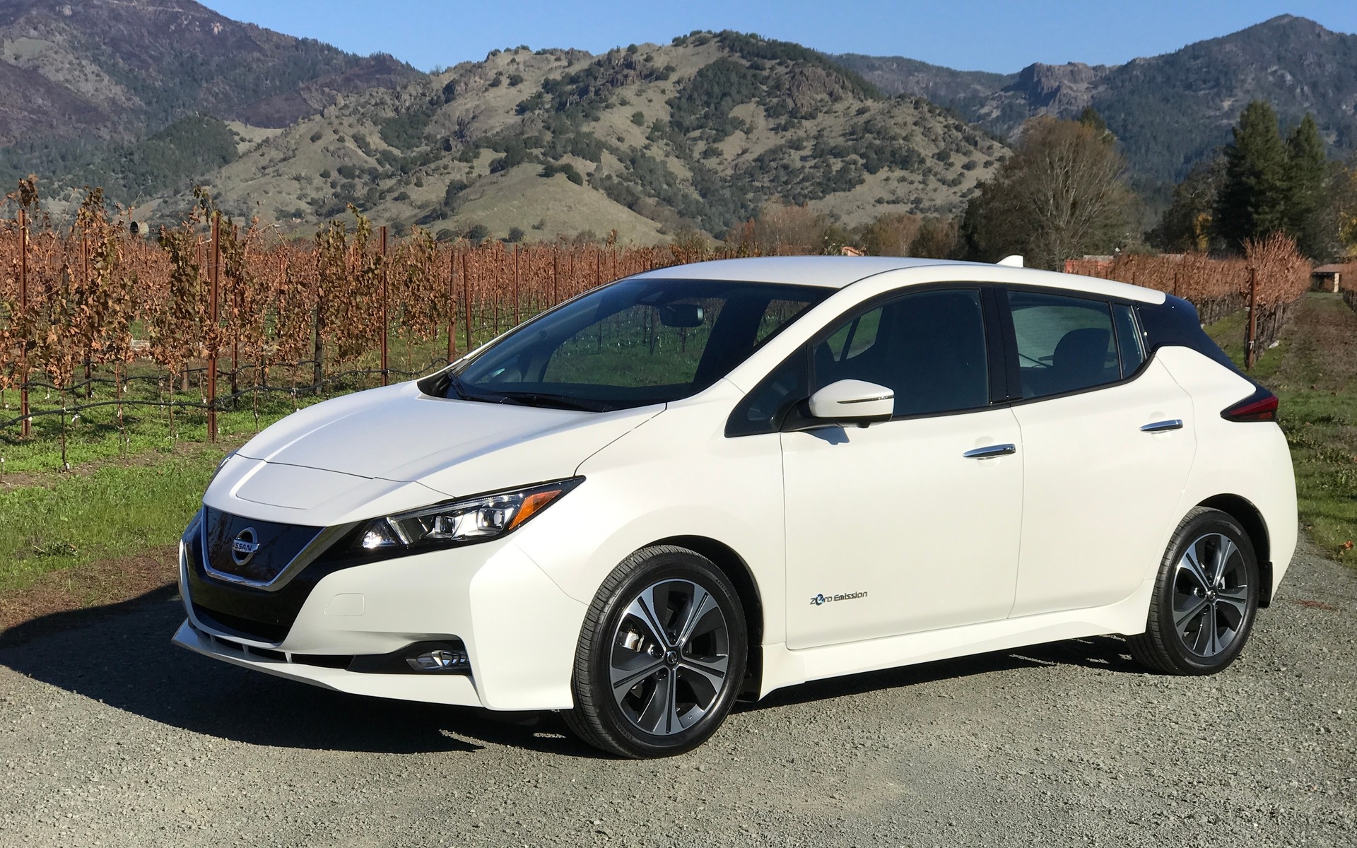 La Nissan Leaf 2018 stationné sur un chemin de gravel avec un arrière plan de montagne.